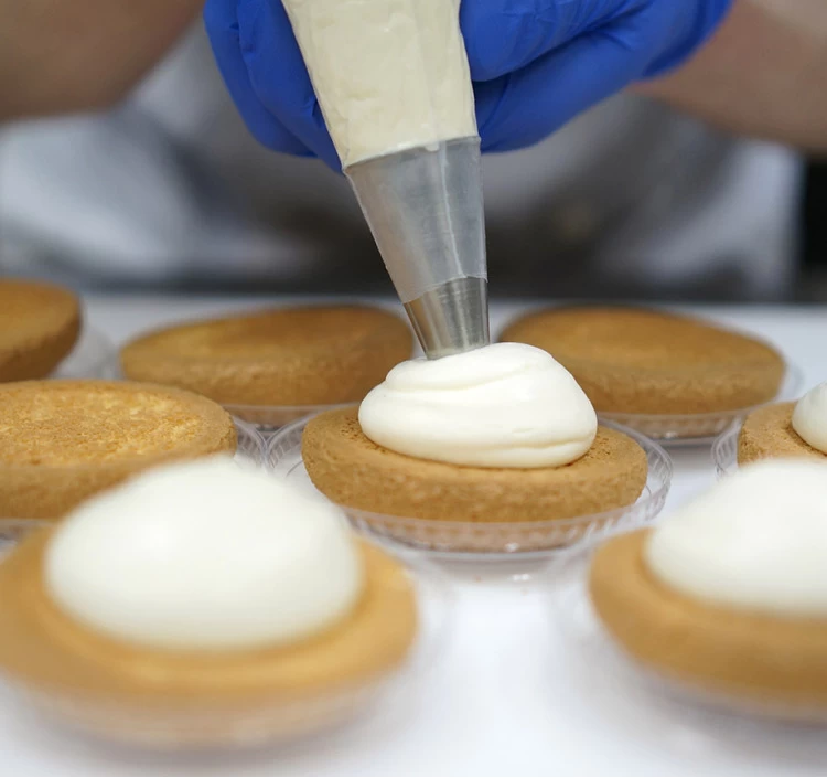 たっぷりの特製クリームを絞っています。