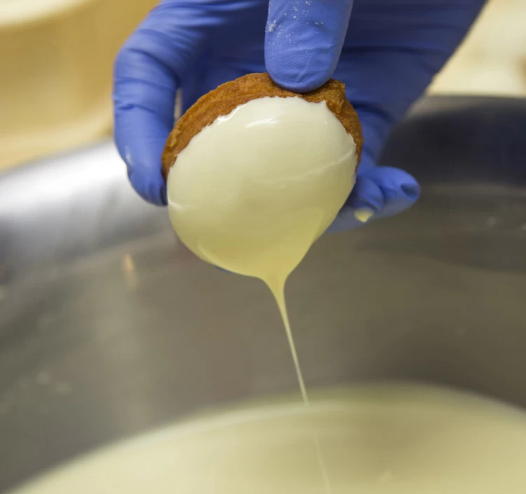 生地にクーベルチュールホワイトチョコレートを丁寧につけています。