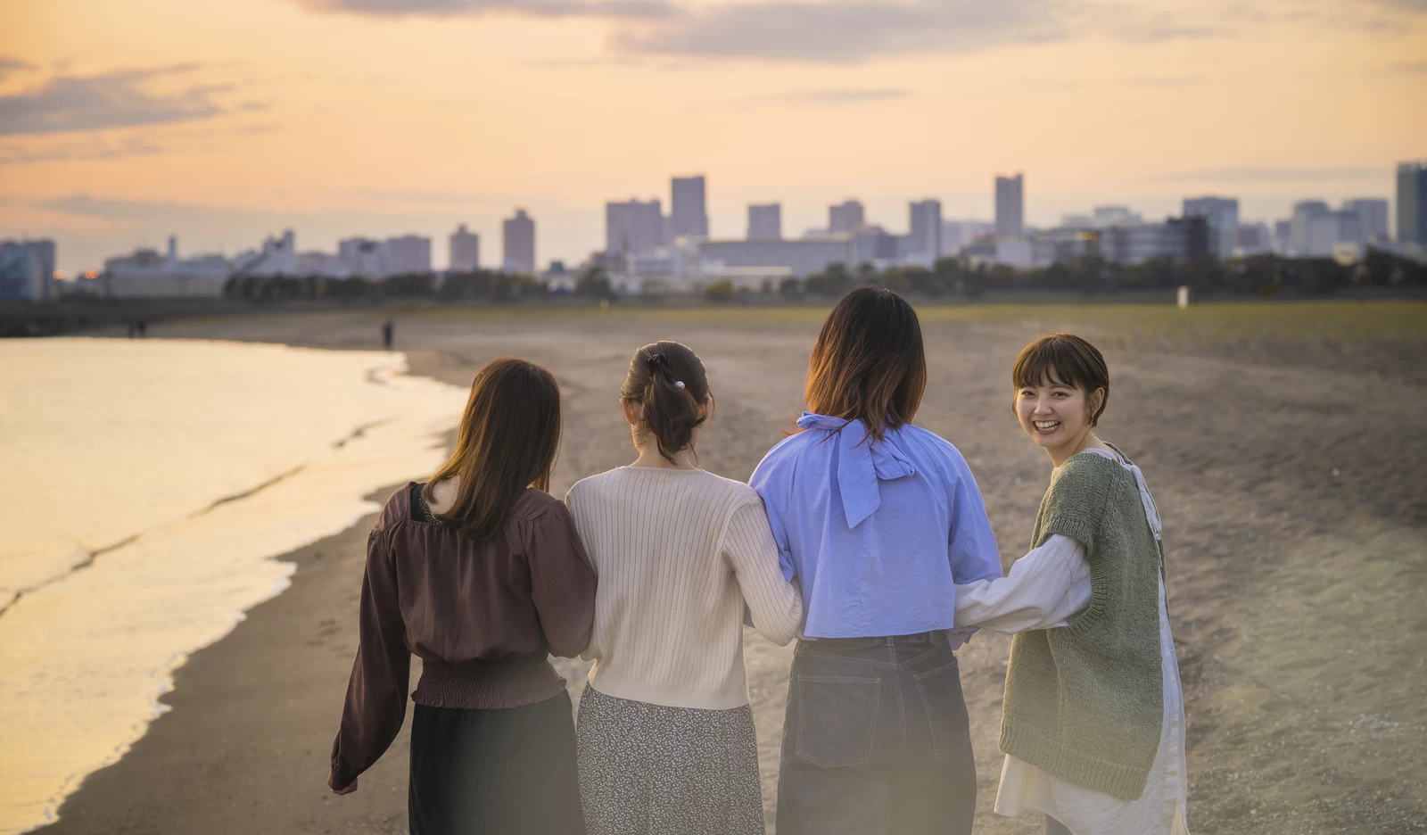 海岸沿いを歩く女性4人組