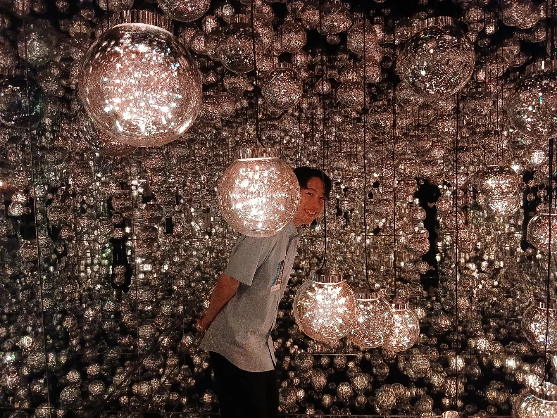 チームラボボーダレス麻布台ヒルズの作品《Bubble Universe》で、光の球体に包まれる来館者
