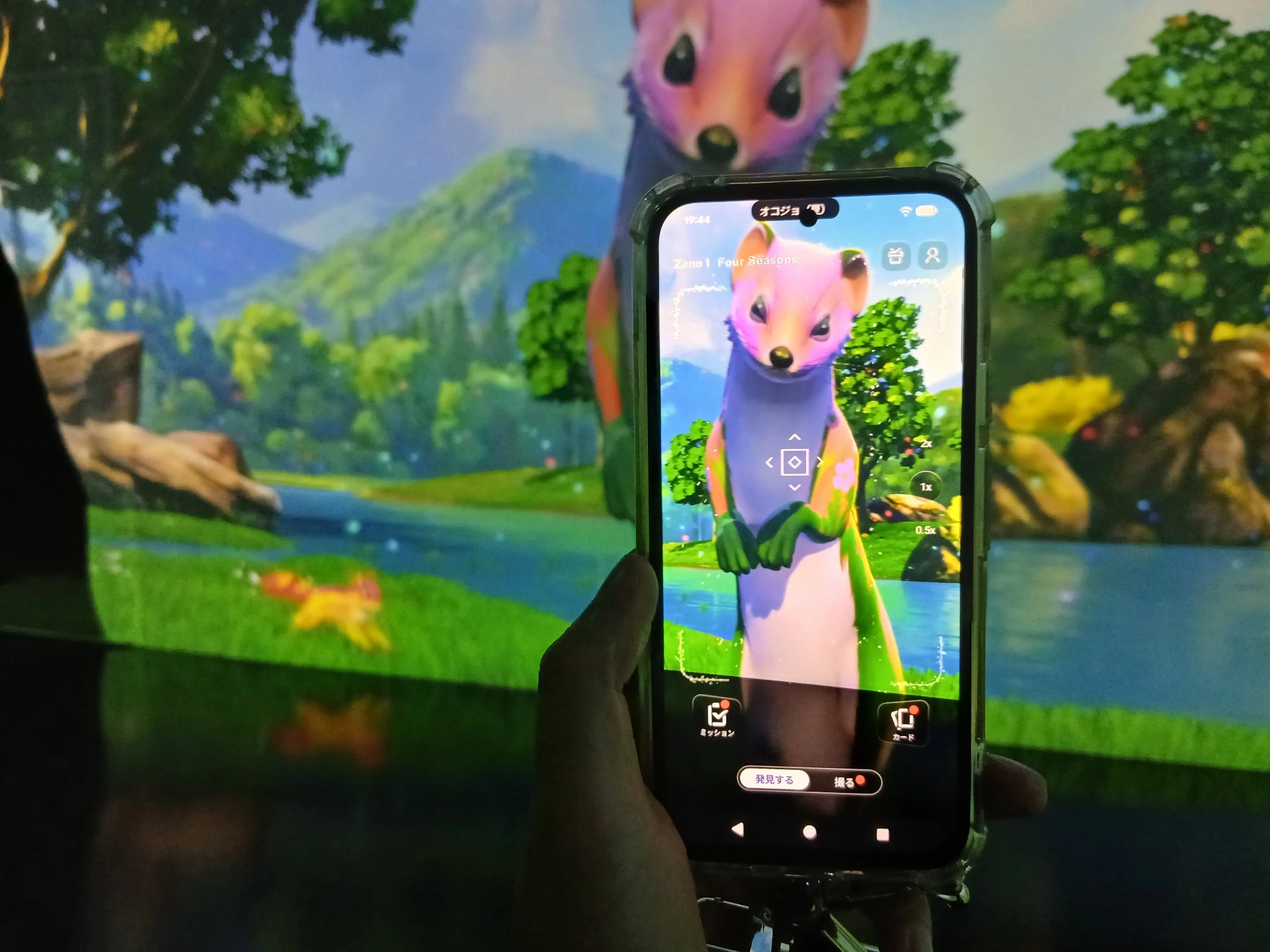 アプリをかざすと、画面に「オコジョ」が登場。ゾーン1「うつろう四季の彩り」では、映像に現れる生き物をその場で見つけて楽しめる。