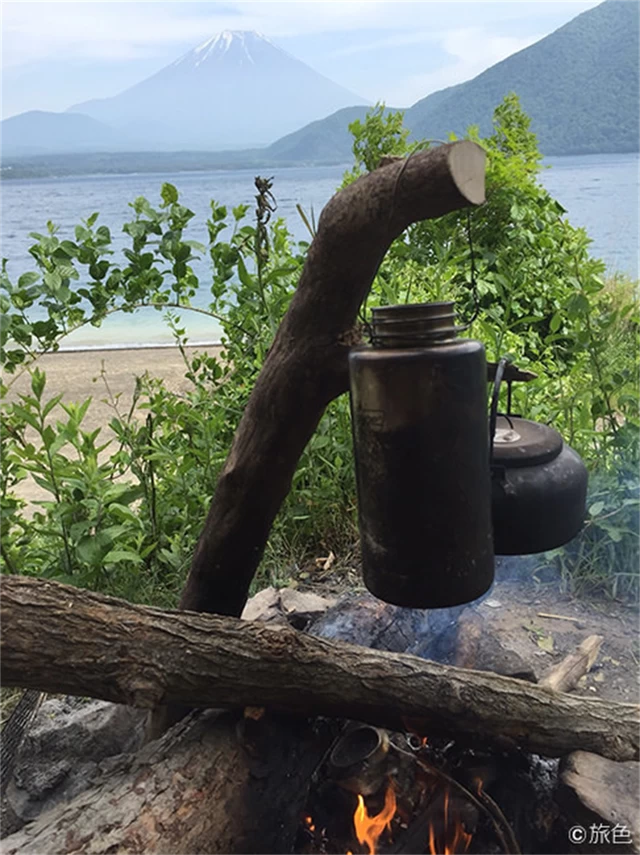 （写真：山梨の浩庵キャンプ場にて。木で組んだスタンドに水筒を吊るして湯を沸かしているところ）