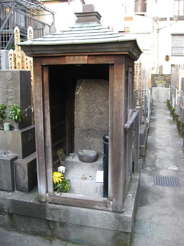 小さなお堂が古い墓を雨風から守っている