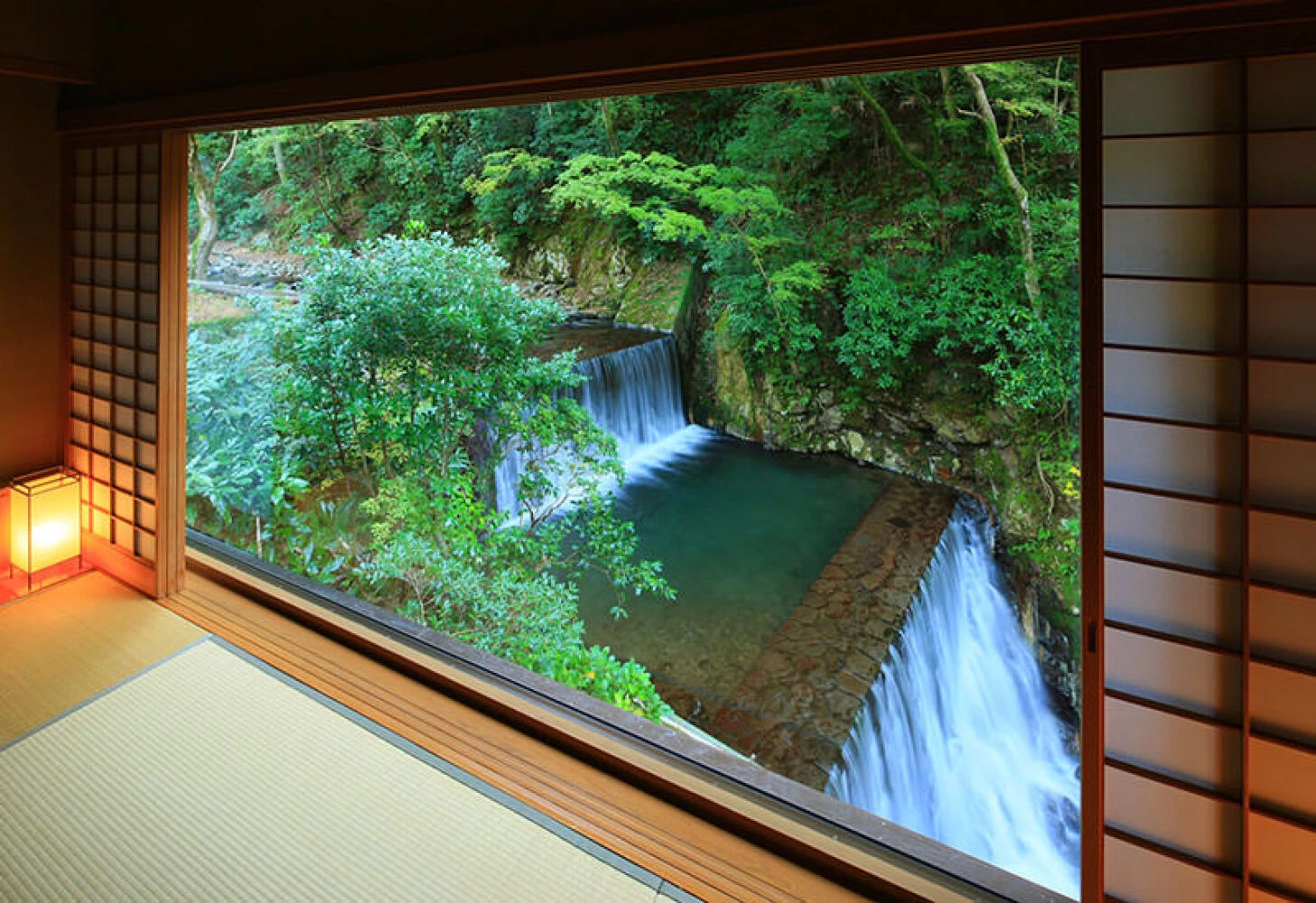 一枚窓から滝を望める本館「結唯」の客室
