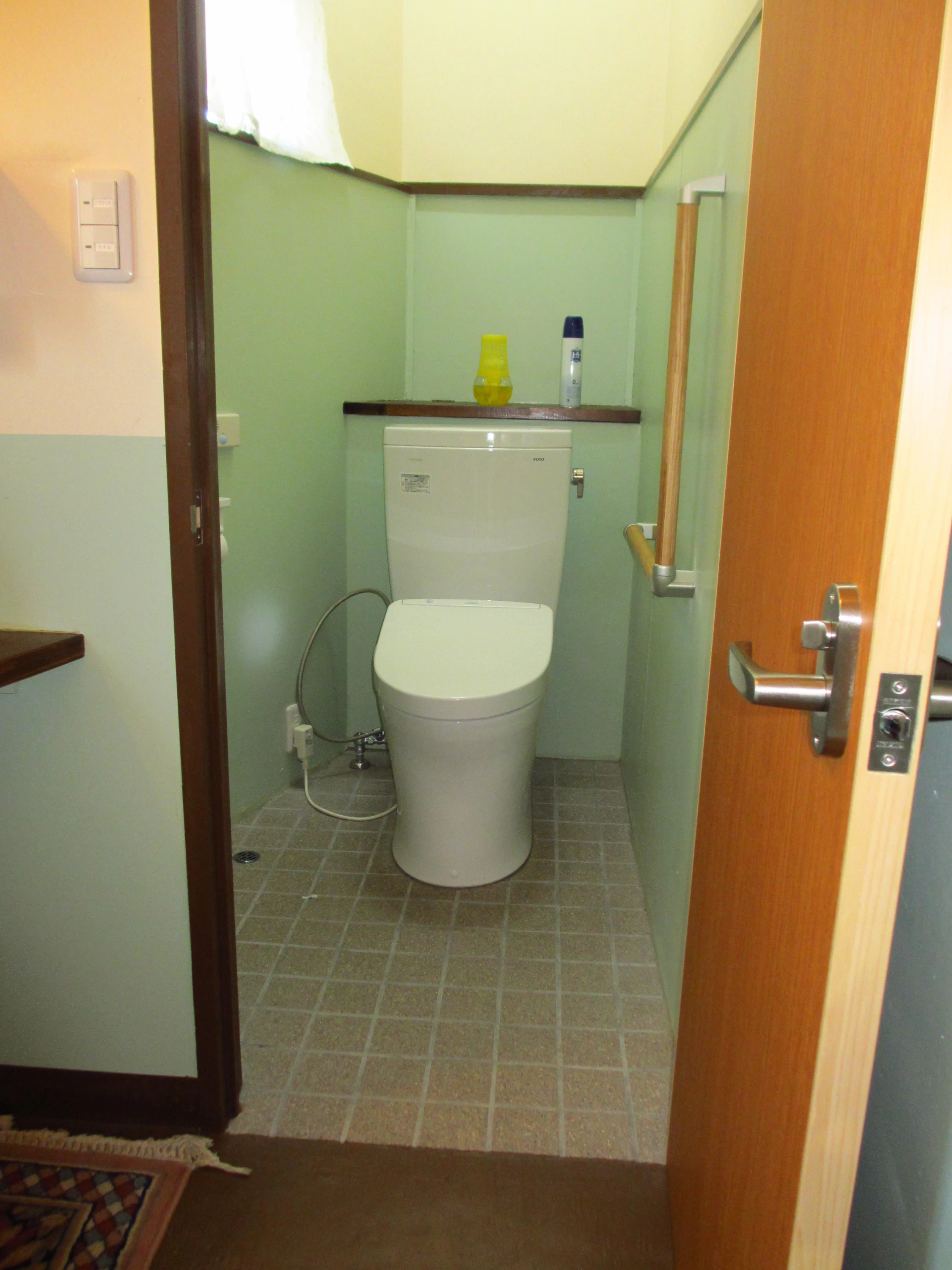 トイレ入口幅60㎝、段差なし。右側にL字手すりあり、温水洗浄便座あり。