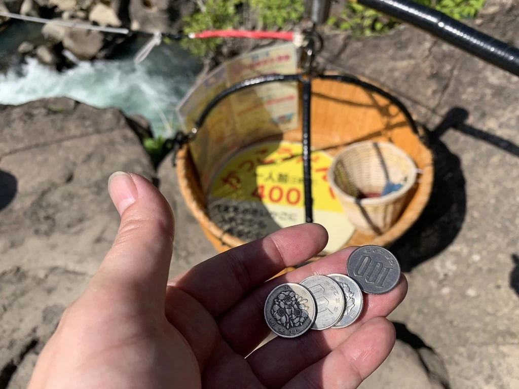 だんごの代金を籠に入れて待つ