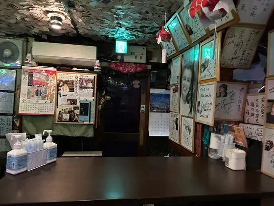 著名人のサインや、お客さんの名刺が隙間なく貼り付けられている内観