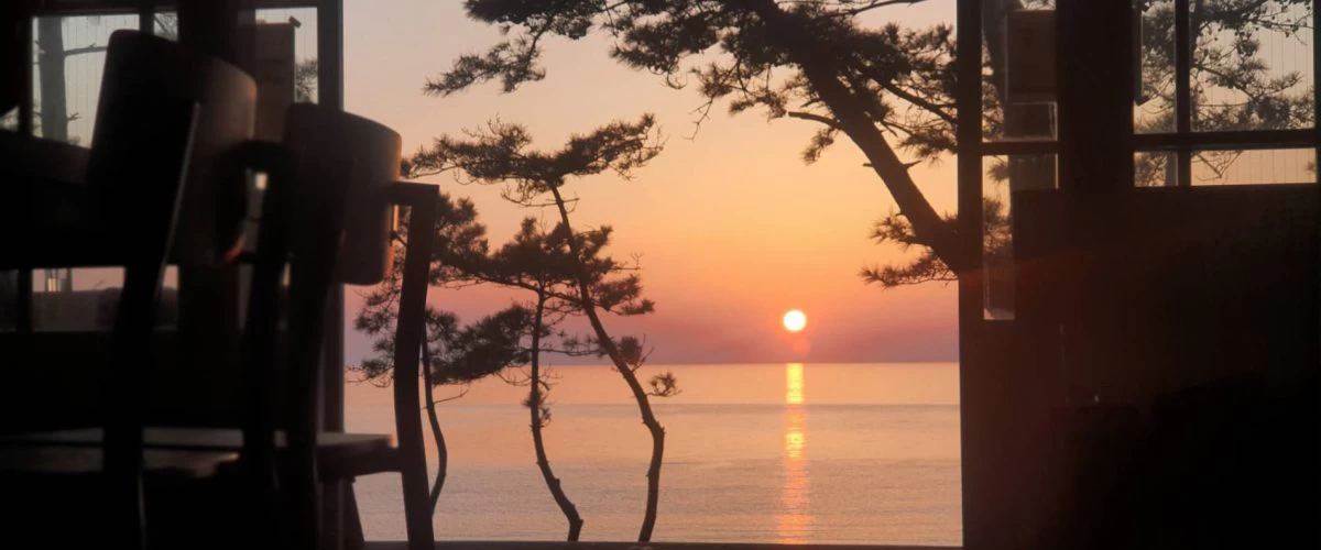 店内から望む海に沈む夕陽