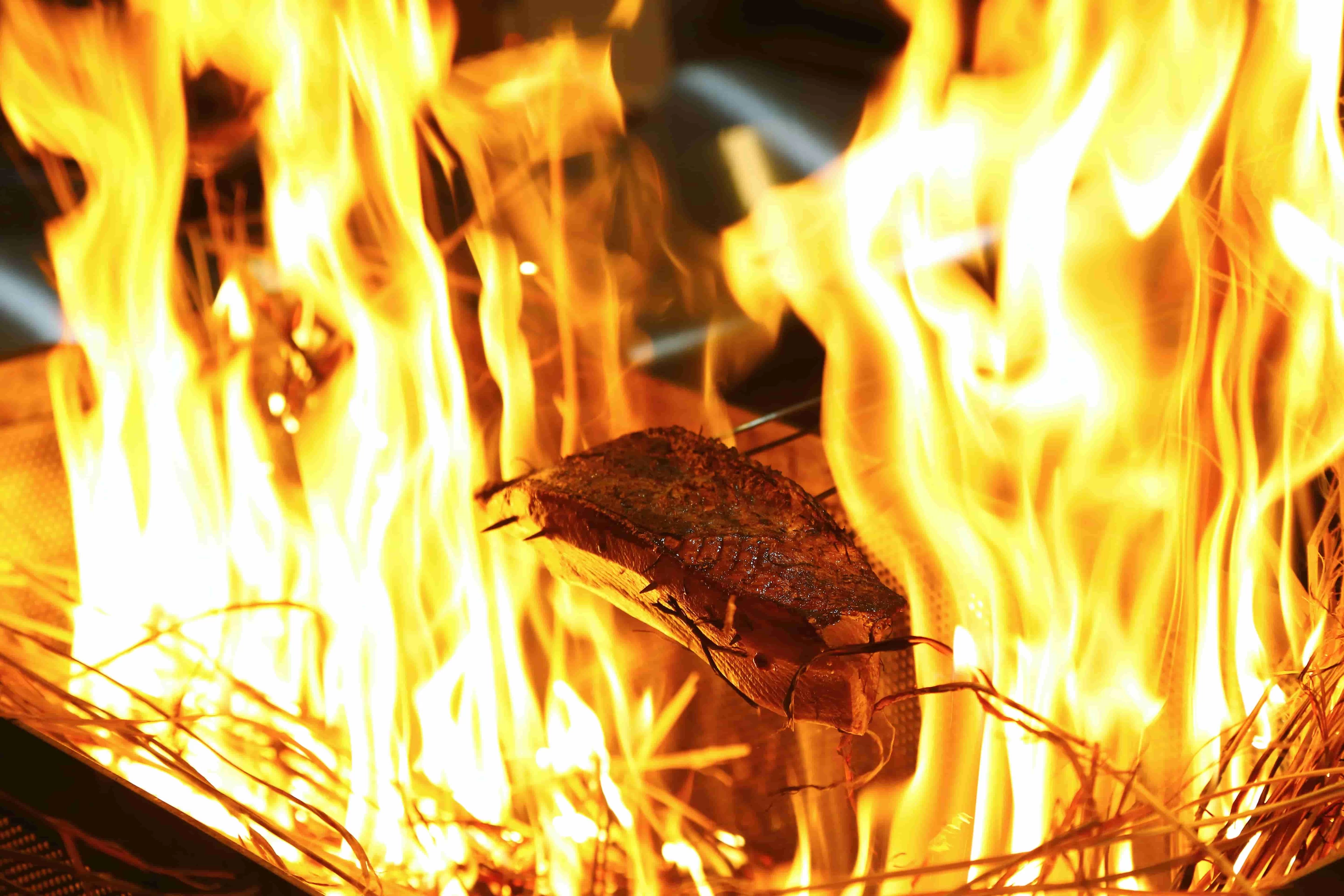 燃えさかる炎でカツオを炙る
