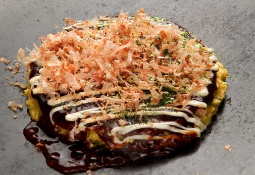 熱い鉄板の上で焼き上がるお好み焼き