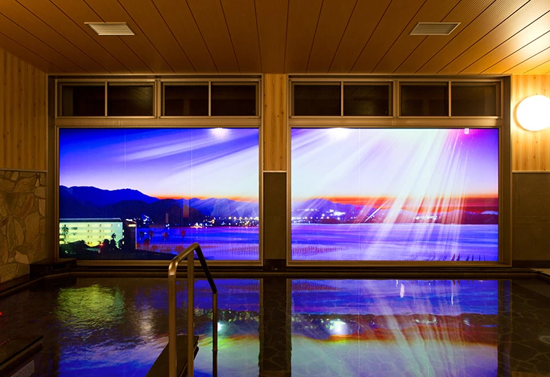 夜はガラス窓が大画面となる“プロジェクションマッピングの湯”